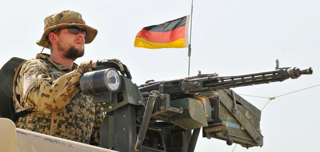 A German soldier of the Camp Marmal Force Protection Group mans a machine gun atop a vehicle, North Afghanistan, August 2011