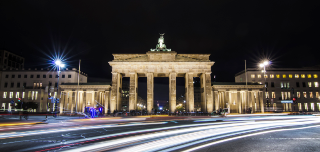 Das Foto zeigt das Brandenburger Tor in Berlin von Westen aus beleuchtet bei Nacht.