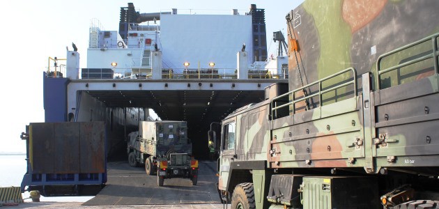 Lkws der Bundeswehr fahren auf ein Fährschiff.
