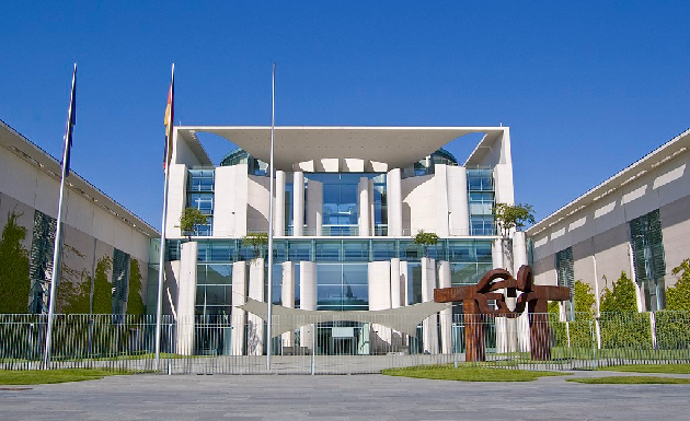 Das Foto zeigt das Bundeskanzleramt in Berlin bei Tag unter blauem Himmel von Osten.