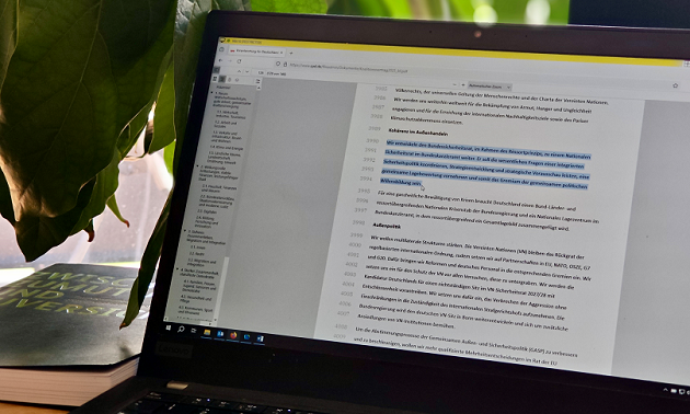 Auf einem Notebookbildschirm wird eine elektronische Version des Koalitionsvertrags zwischen CDU, CSU und SPD 2025 angezeigt, in dem eine Passage zum Nationalen Sicherheitsrat markiert ist.