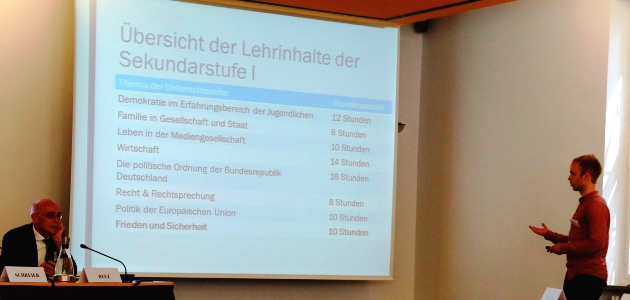 Studienassessor Christian Fringes deutet auf eine Projektion aus Wörtern und Zahlen an einer Wand.