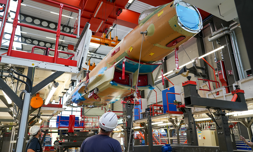 Das Bild zeigt ein Kampfflugzeug vom Typ Eurofighter in der Montage im Airbus-Werk in Manching.