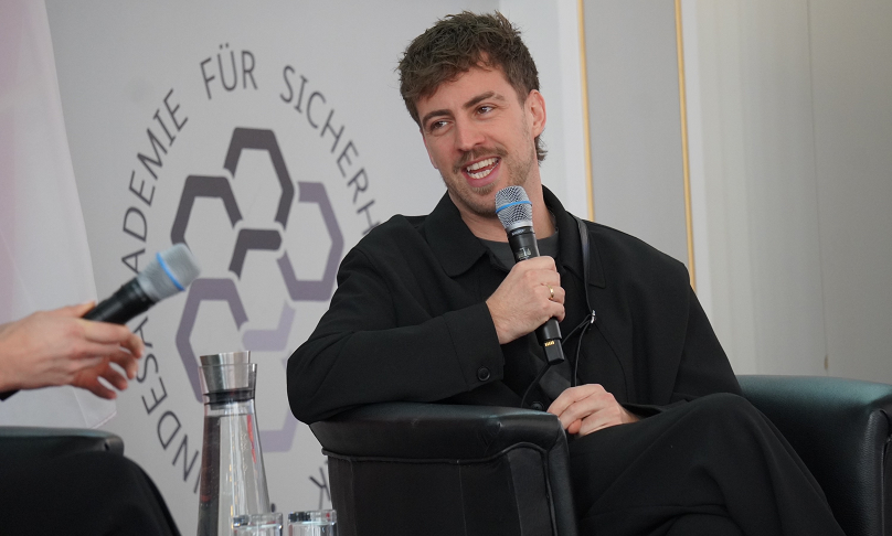 Im Historischen Saal der BAKS spricht David Matei lachend in ein Mikrofon.