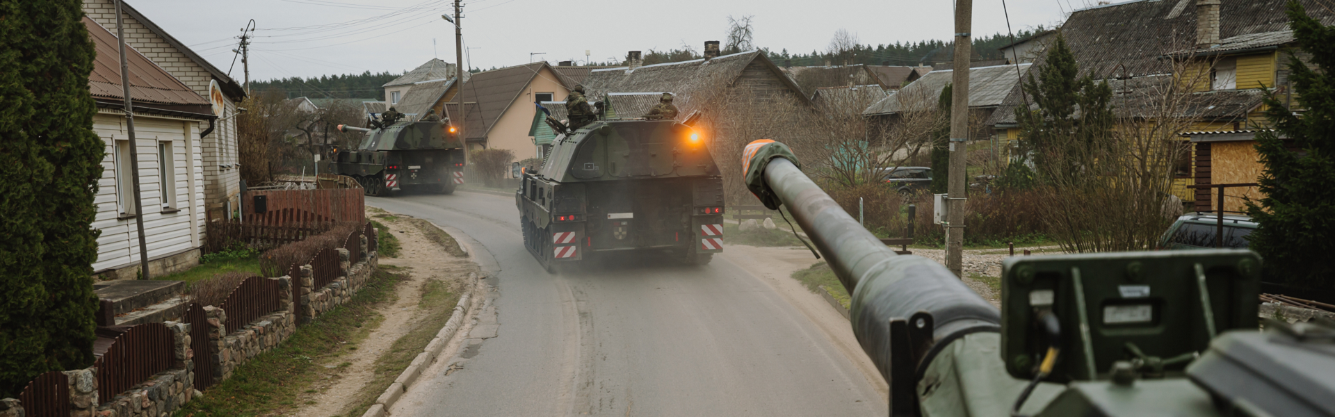 Panzerhaubitzen der Bundeswehr fahren durch ein Dorf in Litauen